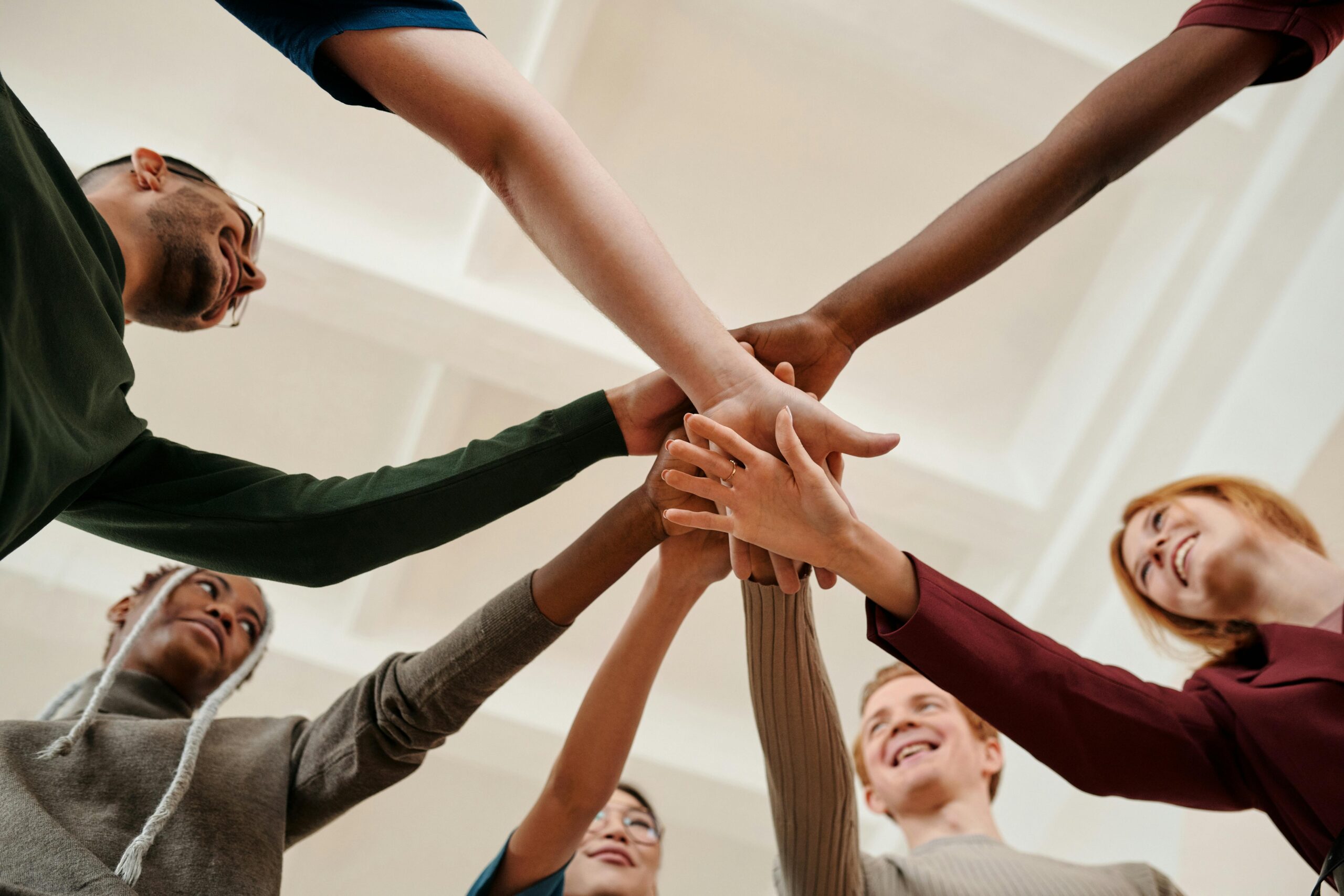 A group of people with their hands in a circle.